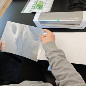 Eine Folie von Leitz wird verwendet, um ein A4-Blatt zu laminieren.