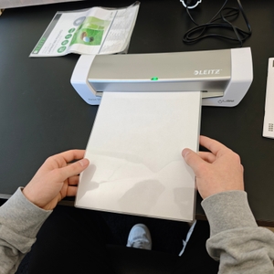 Eine Folie wird in das Laminiergerät Leitz iLAM 73680089 eingeführt.