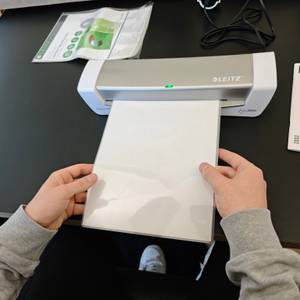Eine Folie wird in das Laminiergerät Leitz iLAM 73680089 eingeführt.