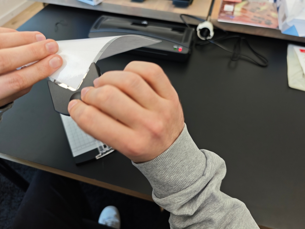 Ein Eckenabrunder wird bei einem laminierten Blatt Papier angewendet.