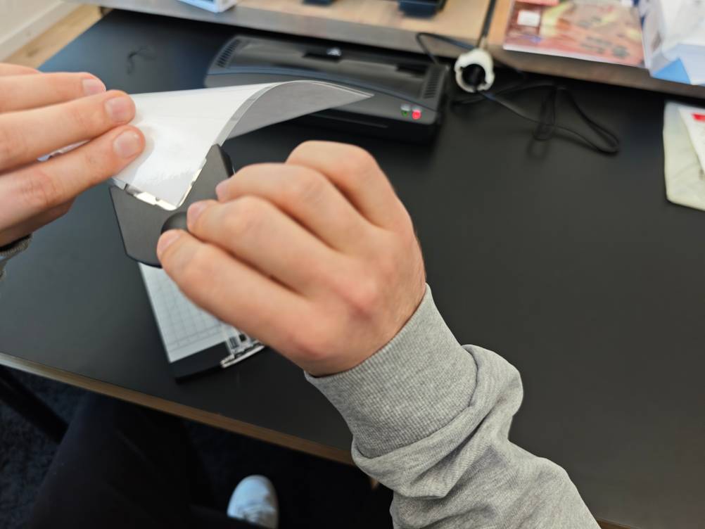 Ein Eckenabrunder wird bei einem laminierten Blatt Papier angewendet.