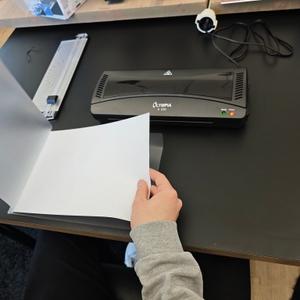 Ein Papier wird in eine Laminierfolie gelegt.