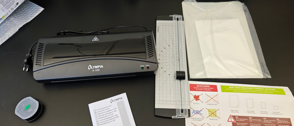 Das Zubehör des Olympia A 230 liegt auf einem schwarzen Tisch.