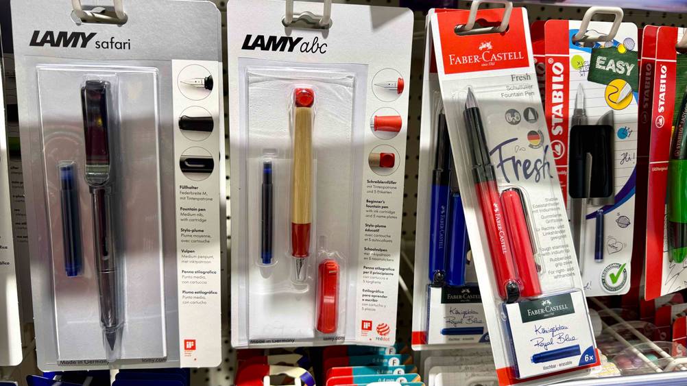 Eine Packung des getesteten Lamy-Füllers in einem Verkaufsregal neben anderen Produkten hängend.