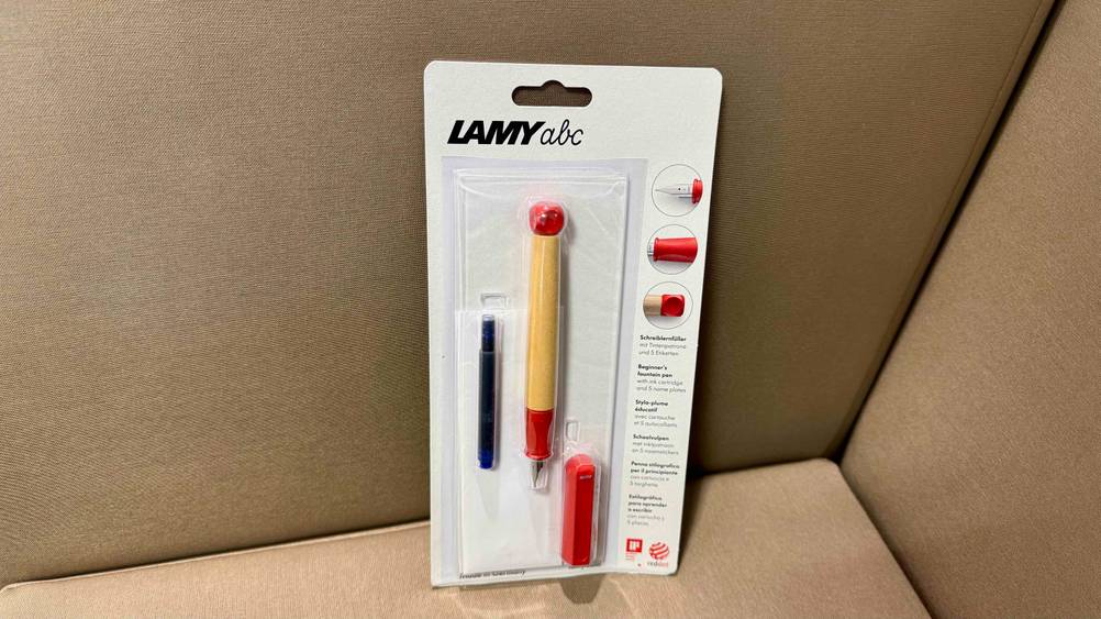 Ein verpackter Lamy-Füller im Test auf einem Polstermöbel.