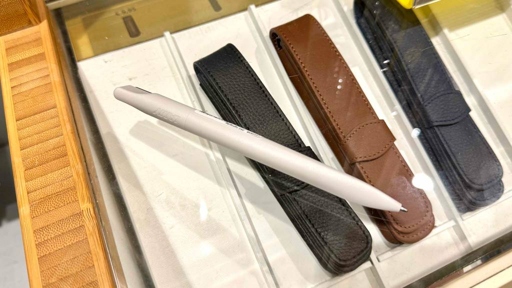 Ein weißer Lamy-Kugelschreiber liegt zum testen auf mehreren Etuis.