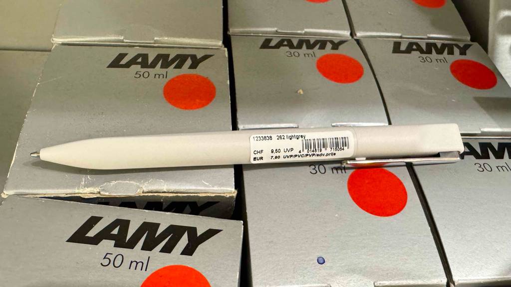 Detailansicht eines getesteten Lamy-Kugelschreibers, der quer auf mehreren Lamy-Kartons liegt.