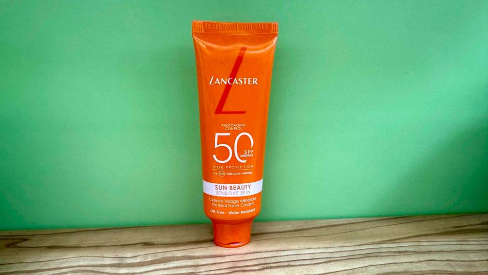 Vor einer grünen Wand steht eine Tube der getesteten Lancaster-Sonnencreme.
