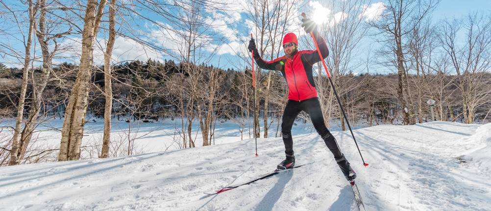 Langlaufhose Herren im Test: Skilangläufer, der durch eine Winterlandschaft fährt