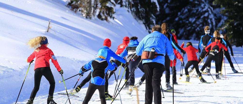 Langlaufhosen für Herren im Test: Gruppe aus unterschiedlich alten Skilangläufern auf der Piste