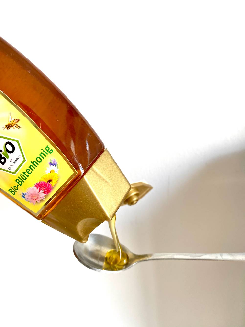 Löffel wird mit Bio-Blütenhonig gefüllt.