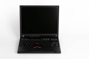 Alter Laptop vor weißem Hintergrund.