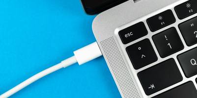 Laptop mit Fokus auf das Ladekabel.
