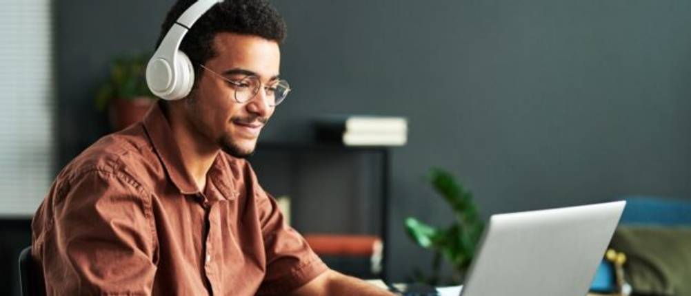 Ein junger Mann an einem Laptop.