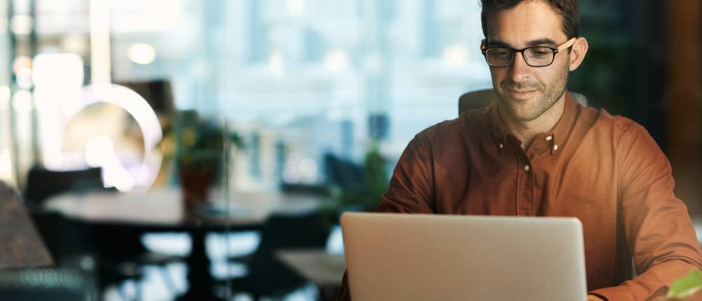 Laptop-bis-500-Euro-Test: Ein Mann mit Brille sitzt vor einem aufgeklappten Laptop.