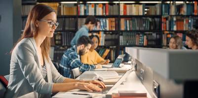 Eine Studentin in der Bibliothek am Laptop.