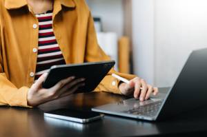 Eine Frau mit Laptop und Tablet.