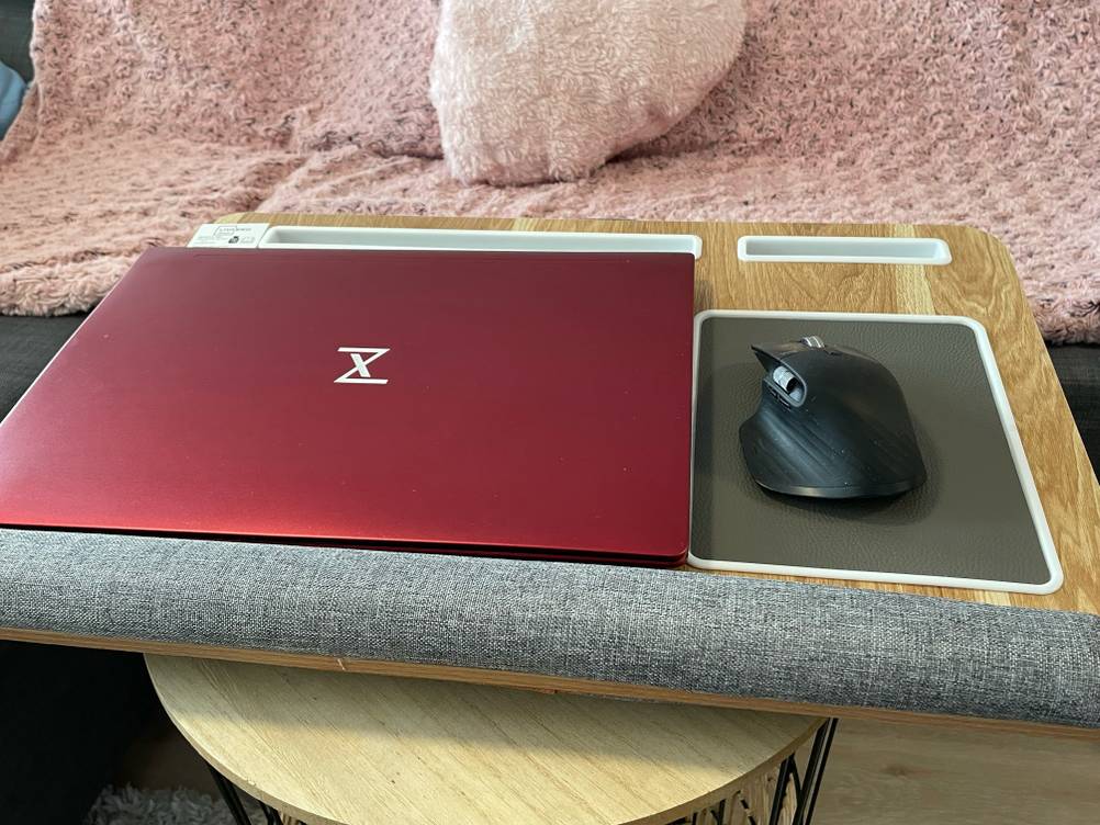 Auf dem getesteten Laptopkissen liegen ein Laptop und daneben eine Mouse.