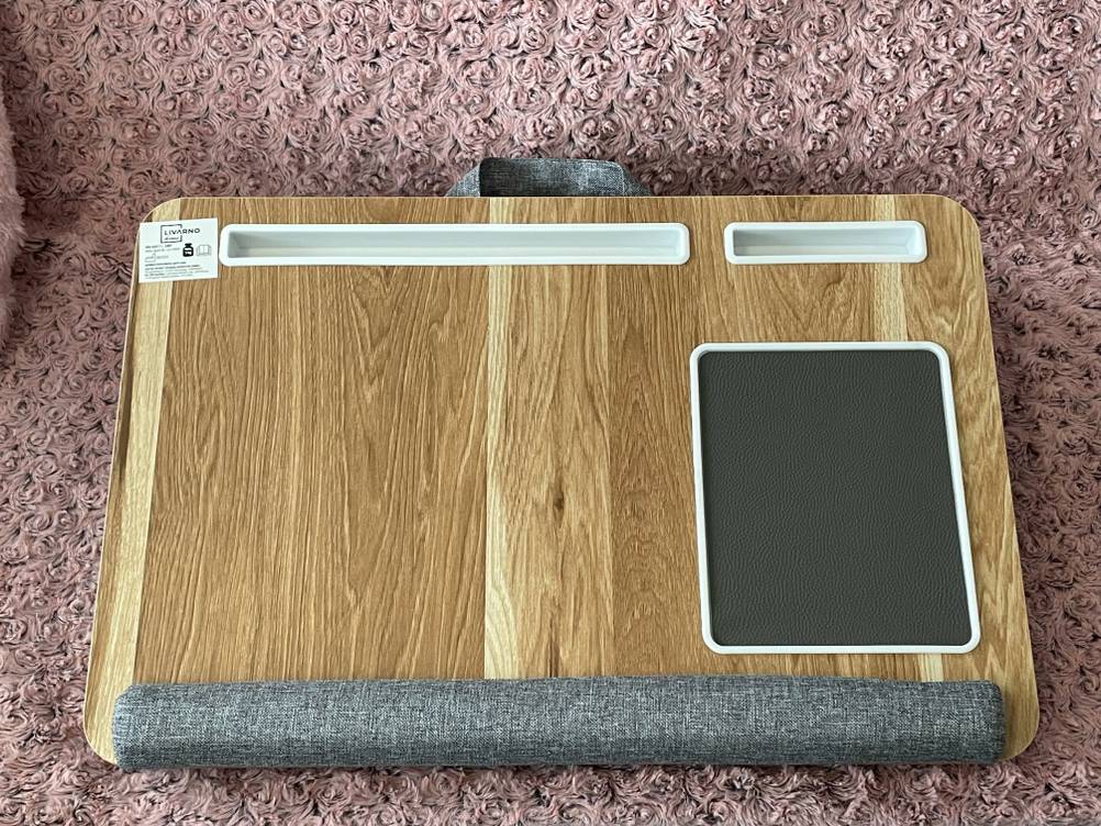 Das getestete Laptopkissen von oben auf einem rosa Stoff liegend.