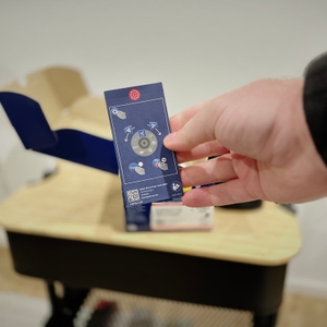 Eine Hand hält eine Quick-Start-Anleitung des Laser-Entfernungsmessers von Bosch.