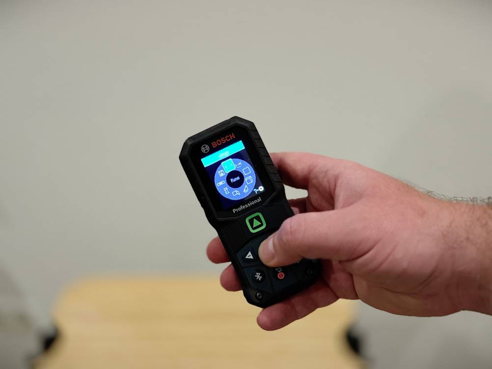 Eine Hand bedient den Laser-Entfernungsmesser von Bosch.