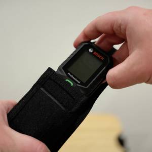 Eine Hand zieht das Gerät aus einer Tragetasche.