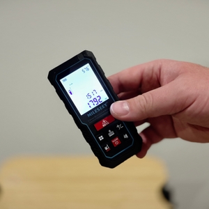 Eine Hand hält das eingeschaltete Produkt schräg vor einem weißen Hintergrund.