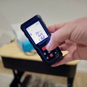 Eine Hand hält das eingeschaltete Produkt schräg.