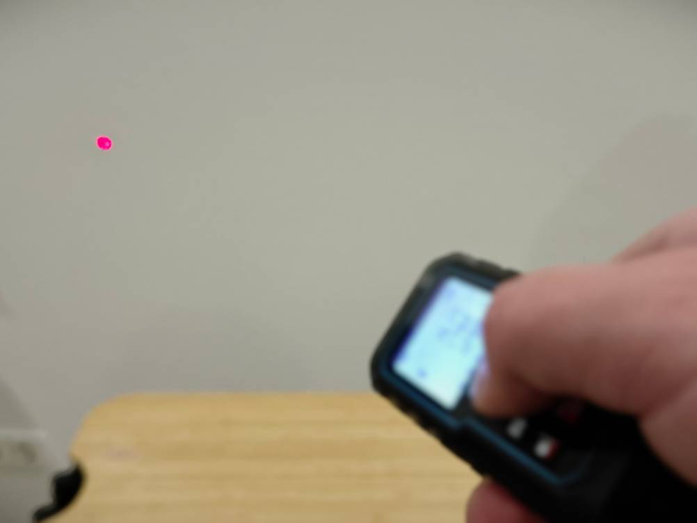 Eine Hand bedient den Laser-Entfernungsmesser von Mileseey.