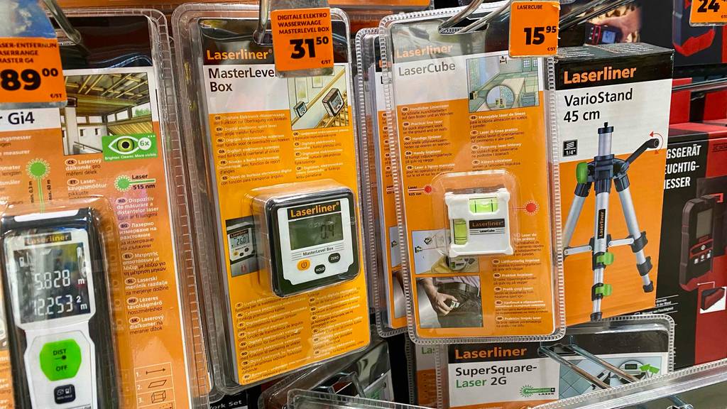 Eine verpackte digitale Wasserwaage hängt zum testen neben anderen Produkten in einem Hänge-Verkaufsregal.