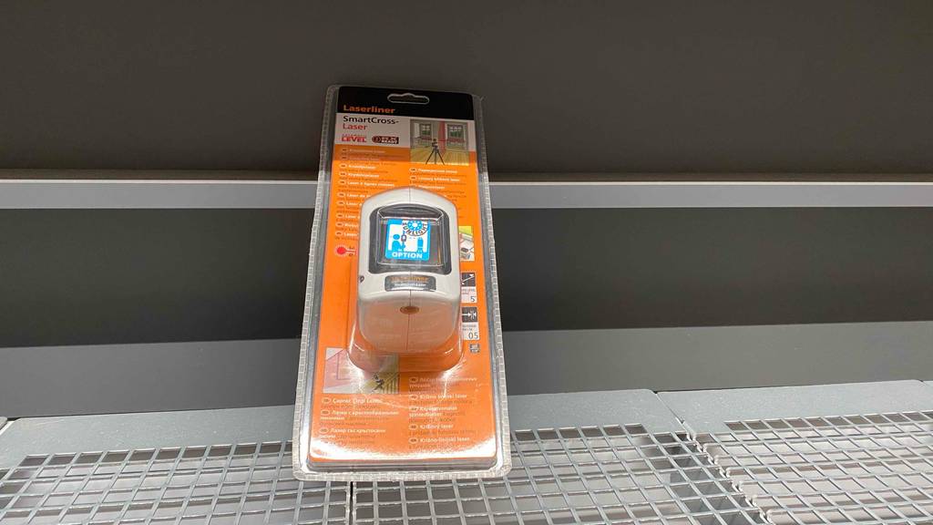 Kreuzlinienlaser-Test: Ein Gerät steht in Originalverpackung in einem Lochregal.