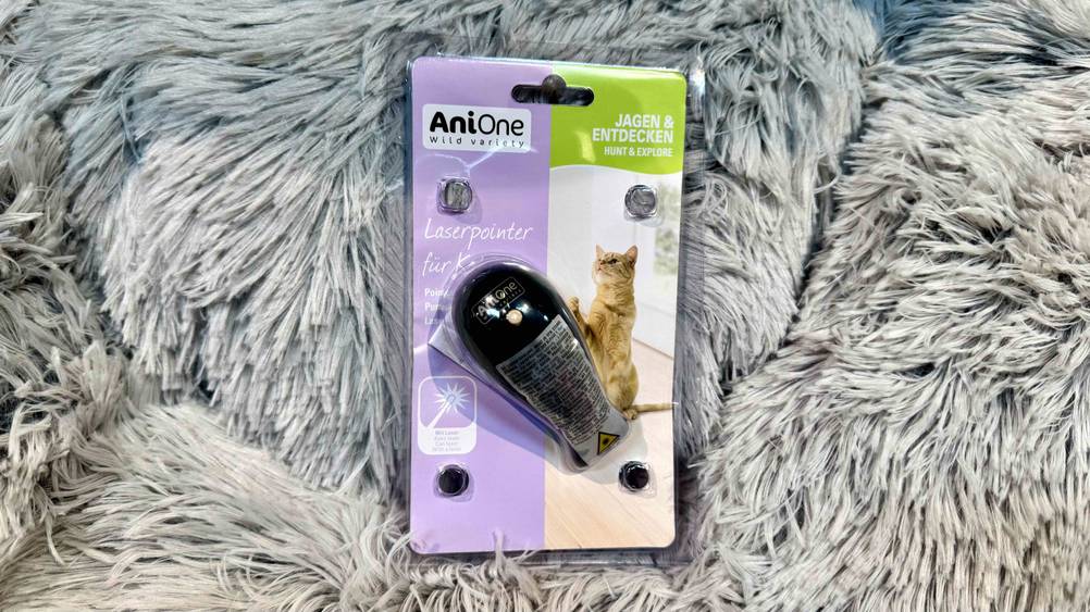 Der getestete Laserpointer für Katzen liegt auf einem grauen Fell.