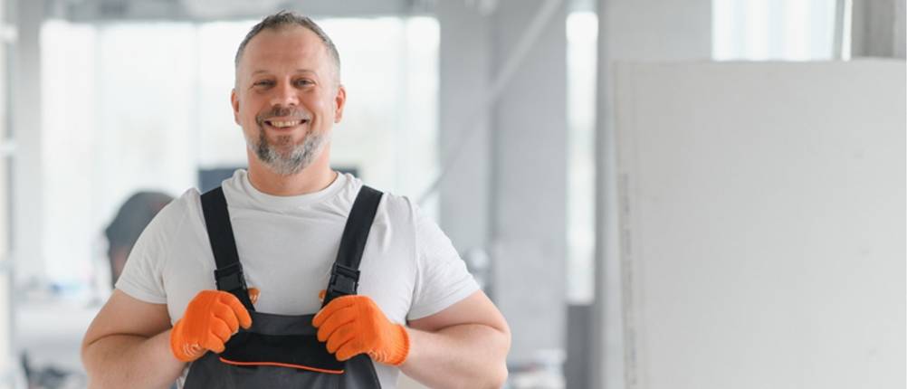 Herren-Latzhosen-Test: Mann in Arbeitslatzhose auf einer Baustelle.