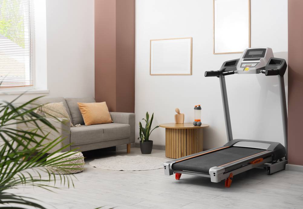 Ein getestetes Laufband mit Steigung steht in einem modernen Wohnzimmer.