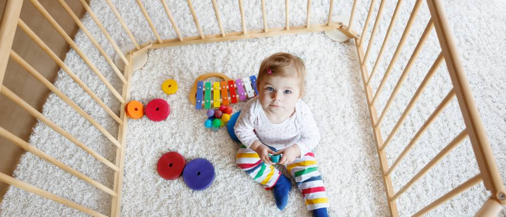Laufgittermatratze im Test: Baby spielt im Laufgitter auf Teppichboden