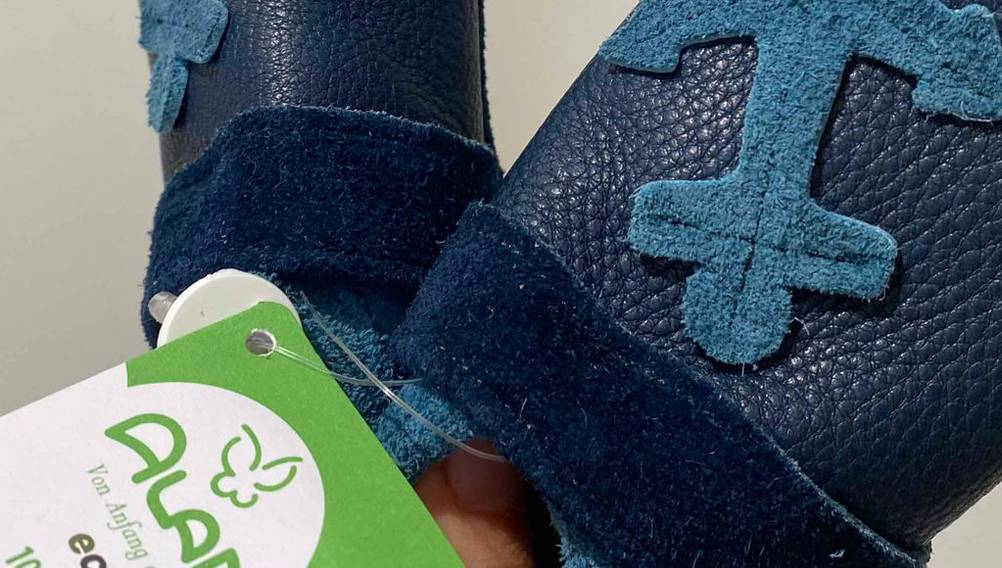 Blaue Lauflernschuhe mit einem Muster.