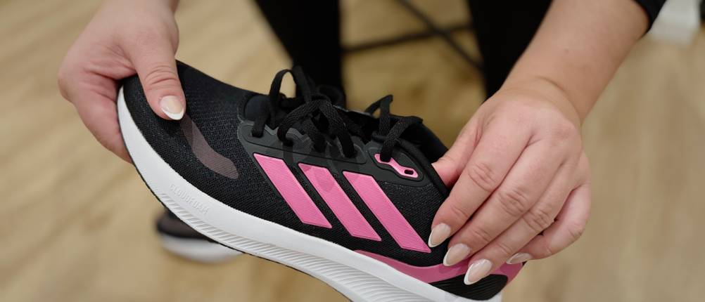 Der Damen-Laufschuh Runfalcon 5 von Adidas wird in der Luft gehalten und ist detailliert zu sehen.