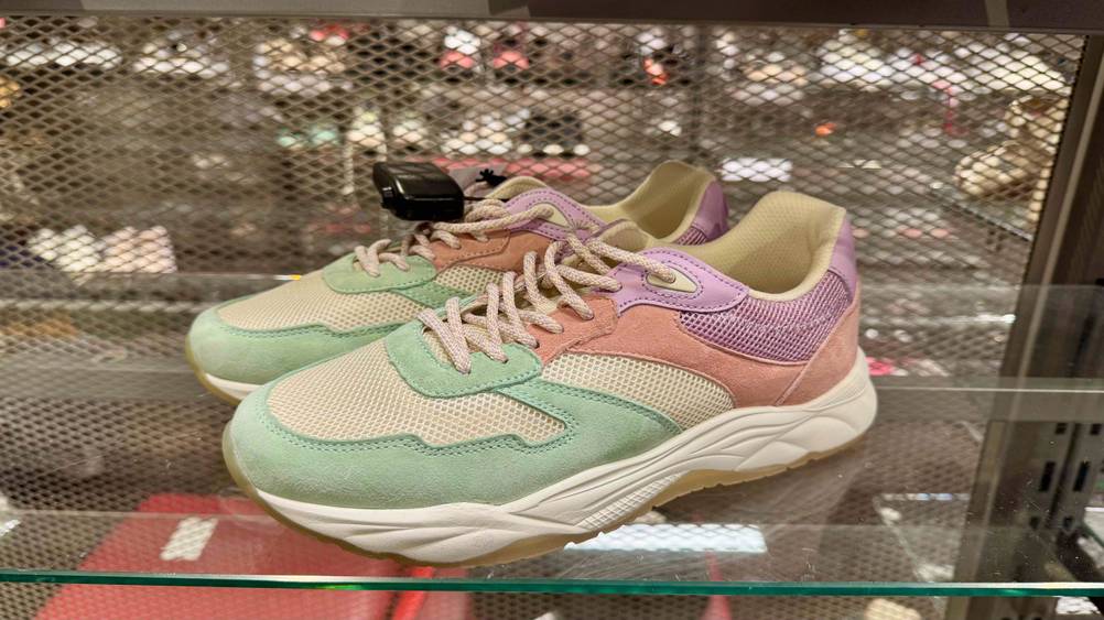 Seitenansicht der getesteten Laufschuhe Damen auf einem Glasregal.