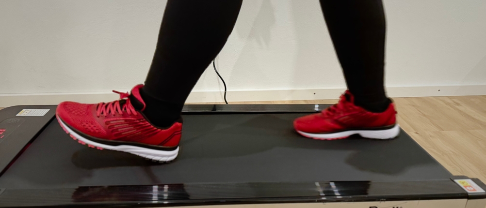 Der Laufschuh von Whitin auf dem Laufband beim Gehen von der Seite.