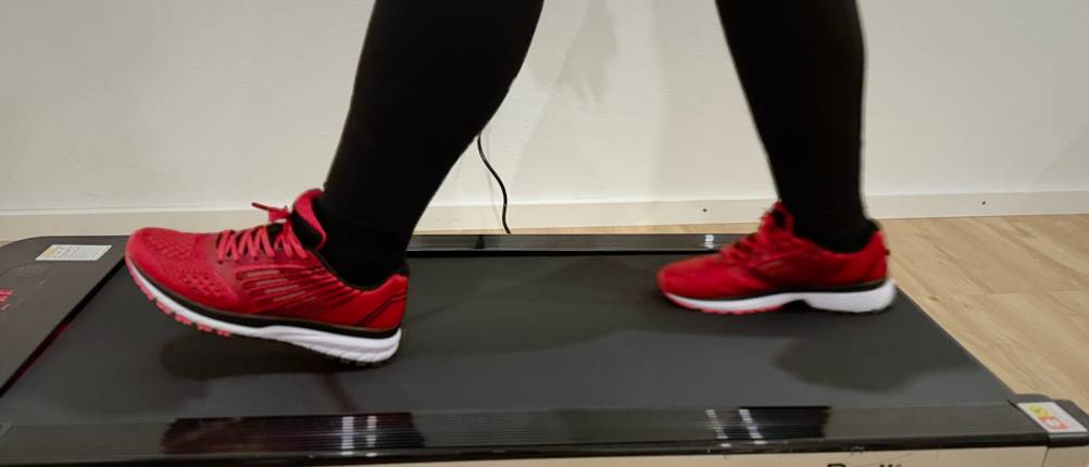 Der Laufschuh von Whitin auf dem Laufband beim Gehen von der Seite.