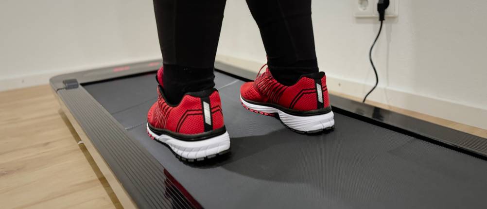 Die Laufschuhe von Whitin sind auf dem Laufband stehend von hinten zu sehen.