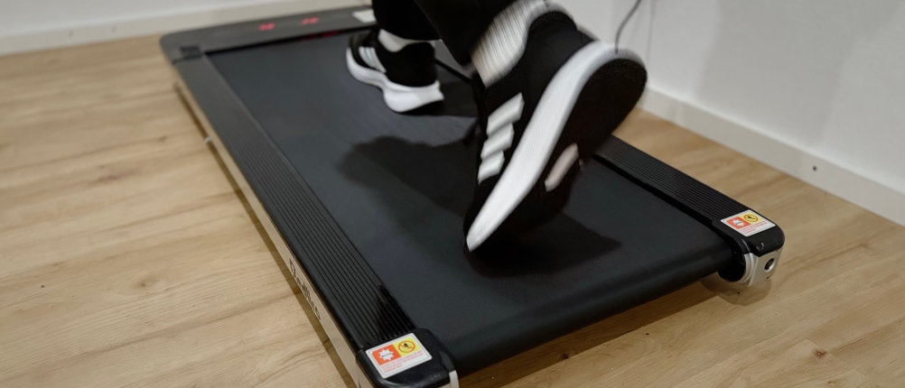 Eine Person läuft auf einem Laufband und trägt dabei Adidas Runfalcon 5 Laufschuhe.