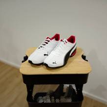 Weiße Puma Tazon 6 FM stehen auf einem Holzhocker.