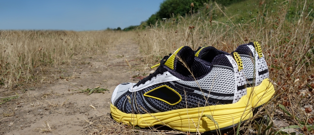 Joggingschuhe stehen auf einem Feldweg.