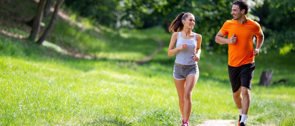 Laufshirt im Test: Frau und Mann laufen in der Natur.