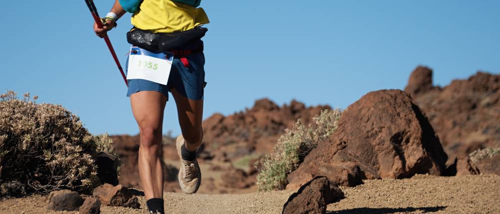 Laufweste für Herren im Test: Trailrunning-Läufer bei einem Ausdauerlauf-Wettkampf auf einem vulkanischem Berg