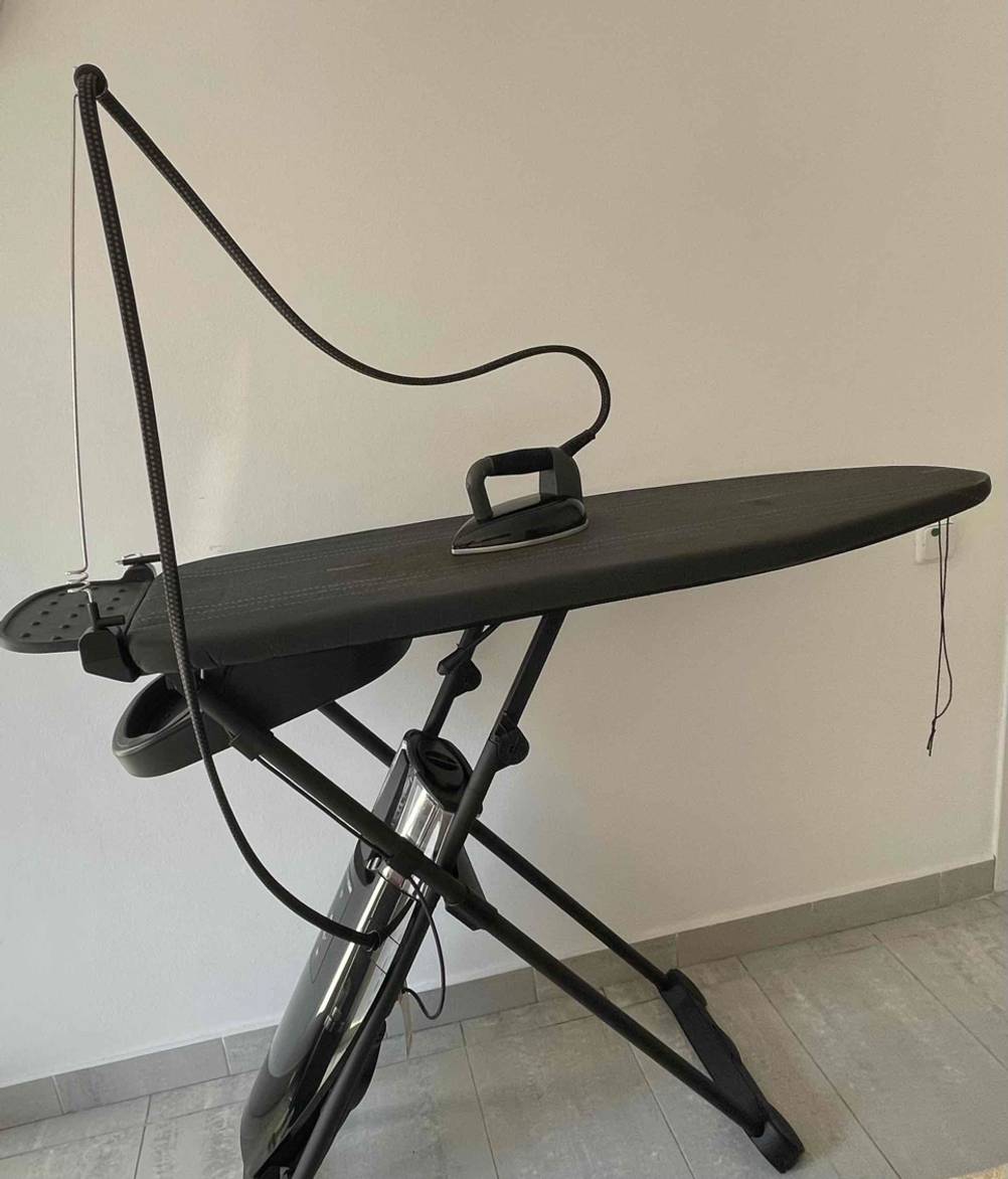 Ein Bügelsystem steht zum testen aufgestellt in einem Zimmer an einer weißen Wand.