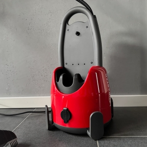 Dampfbügelstation Laurastar Lift Original Red steht auf einem Boden