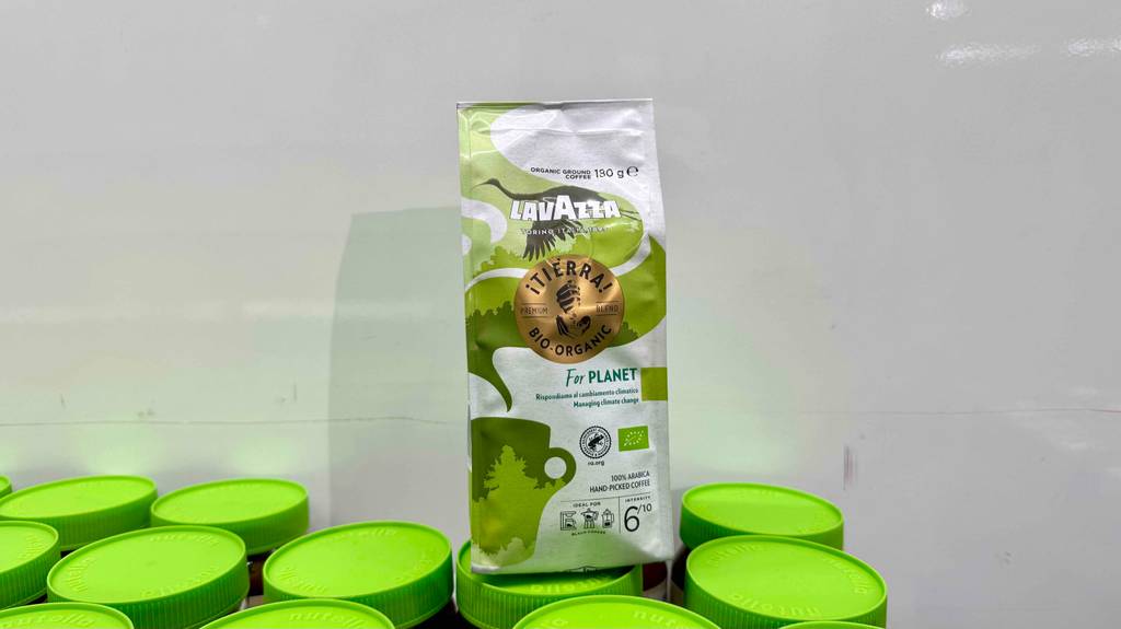 Eine Packung Lavazza-Kaffee steht zum testen auf grünen Deckeln.