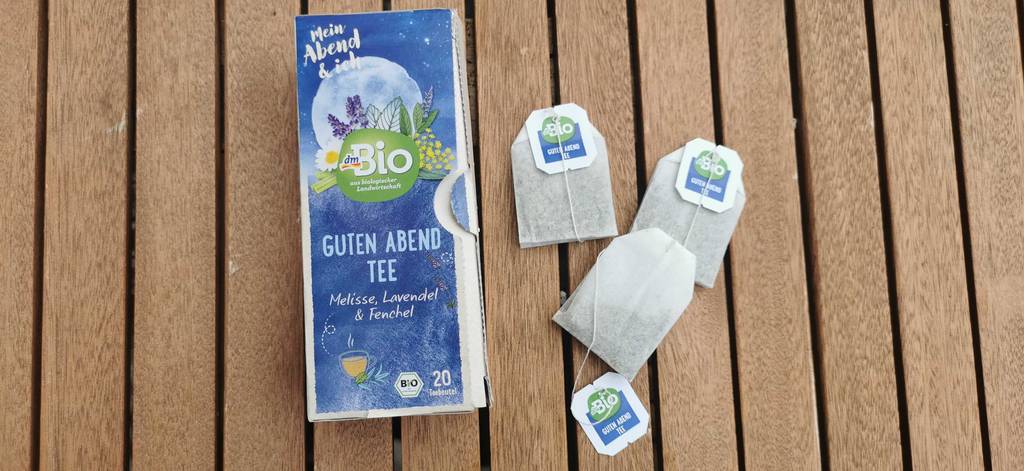 3 Teebeutel und eine Packung lavendeltee auf einer Holzoberfläche 